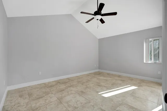an empty room with a ceiling fan and carpet
