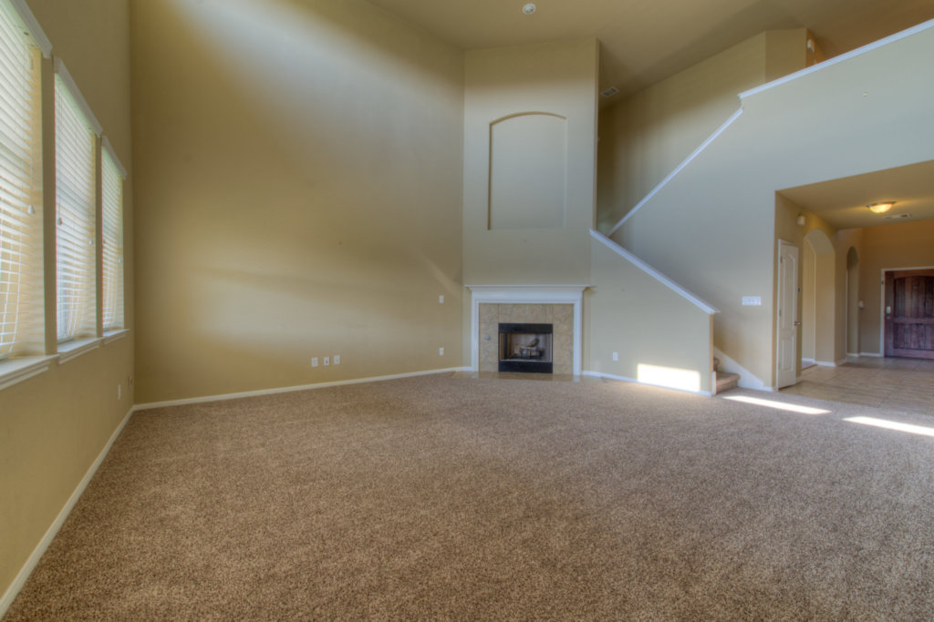 403 Limestone Trail Austin, TX 78737 - Photo 9 of 18 A spacious living area features high ceilings, a fireplace, and an elegant staircase leading to the upper level.
