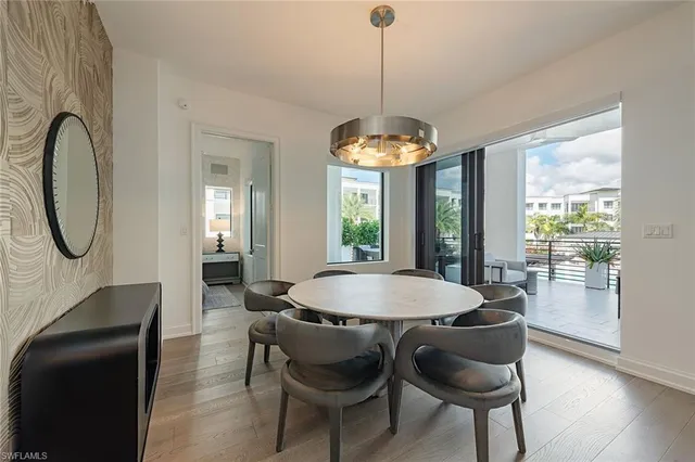 a dining room with furniture a chandelier and wooden floor