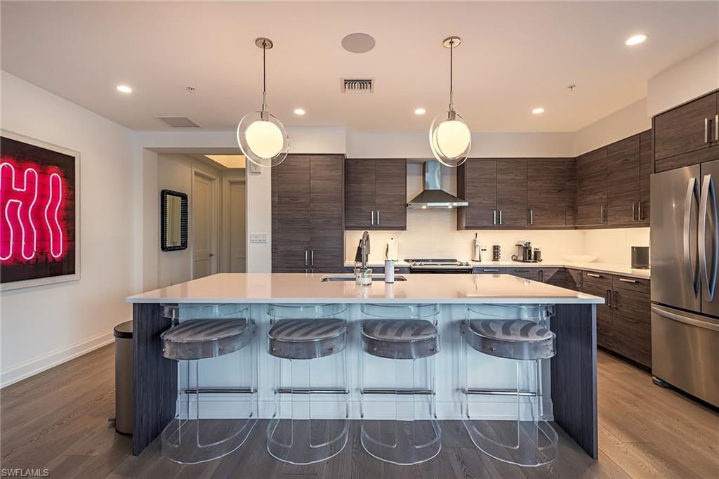 1111 Central Avenue, Unit 310 Naples, FL 34102 - Photo 3 of 12 a kitchen with stainless steel appliances granite countertop wooden cabinets a stove a sink and a refrigerator