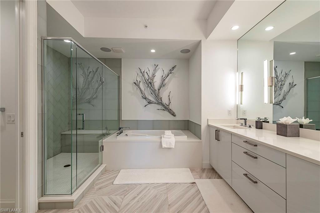 1111 Central Avenue, Unit 310 Naples, FL 34102 - Photo 4 of 12 a en suite bathroom with a shower sink and mirror