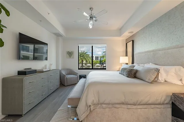 a bedroom with a large bed and a flat screen tv