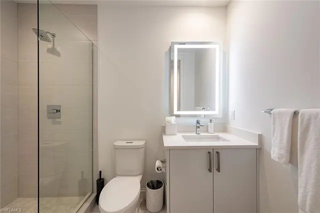 a bathroom with a toilet sink vanity and shower