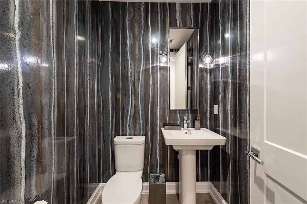 1111 Central Avenue, Unit 310 Naples, FL 34102 - Photo 10 of 12 a bathroom with a sink a mirror and a toilet