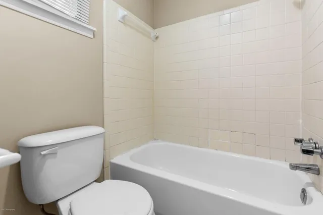 a white toilet and tub sitting next to a bathroom sink