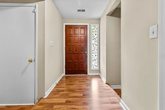 a view of a hallway with wooden floor and windows