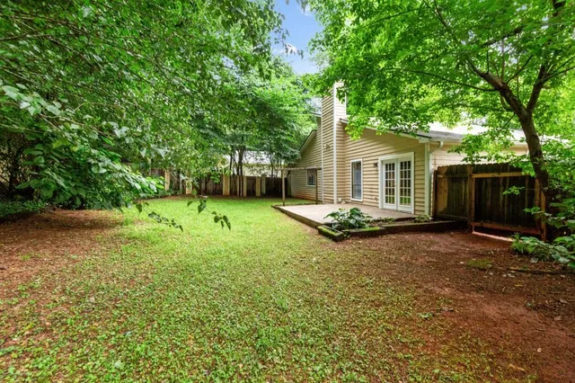 a view of a house with backyard and tree