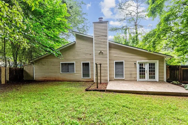 a backyard of a house with table and chairs