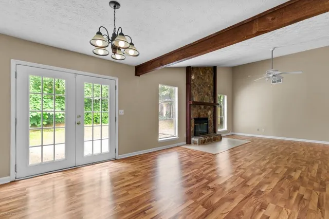 a view of an empty room with wooden floor barbeque and a window