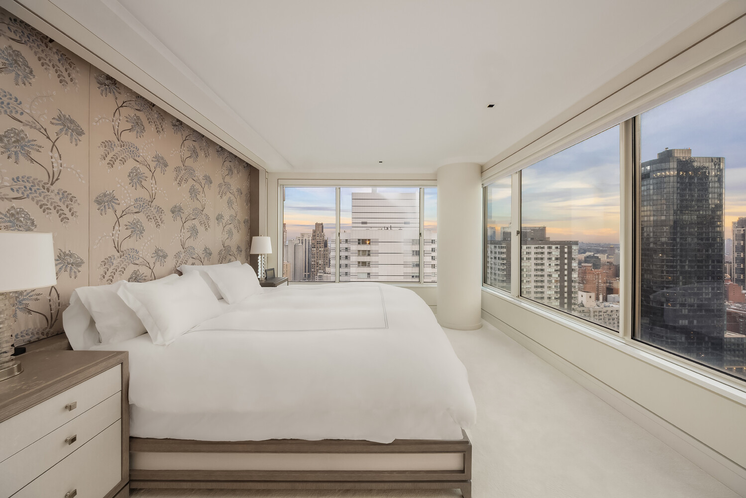 200 East 69th Street, Unit 31C Manhattan, NY 10021 - Photo 10 of 19 a large white bed sitting in a bedroom next to a large window