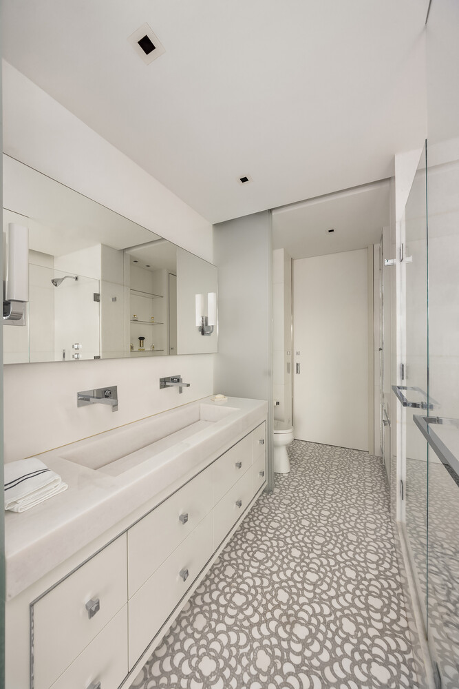 200 East 69th Street, Unit 31C Manhattan, NY 10021 - Photo 11 of 19 a bathroom with a double vanity sink a toilet and a mirror