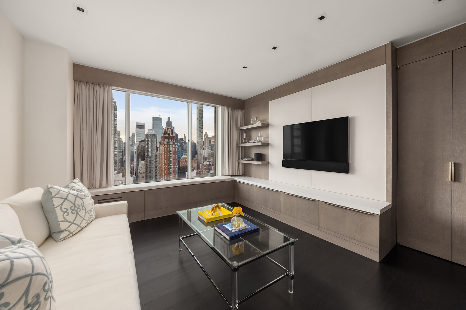 200 East 69th Street, Unit 31C Manhattan, NY 10021 - Photo 15 of 19 a living room with a flat screen tv and a window