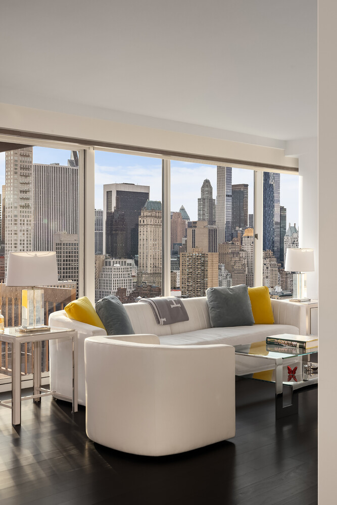 200 East 69th Street, Unit 31C Manhattan, NY 10021 - Photo 3 of 19 a living room with furniture and a large window