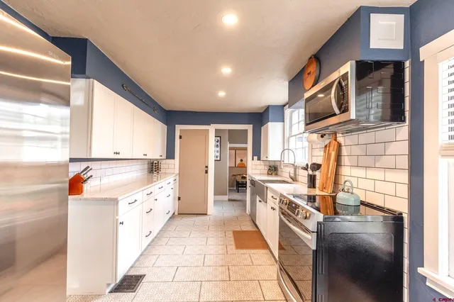 a large kitchen with stainless steel appliances granite countertop a stove and a sink
