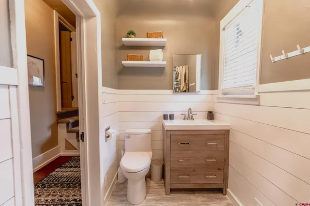 a bathroom with a granite countertop toilet sink and mirror