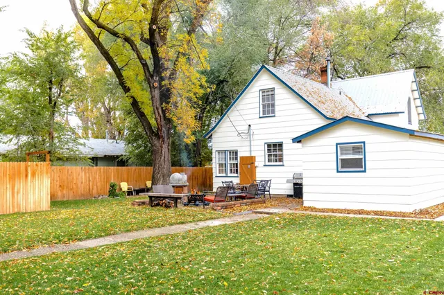 a view of a house with backyard and sitting area