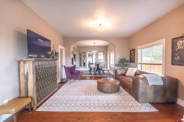 a living room with furniture a rug a fireplace and a flat screen tv