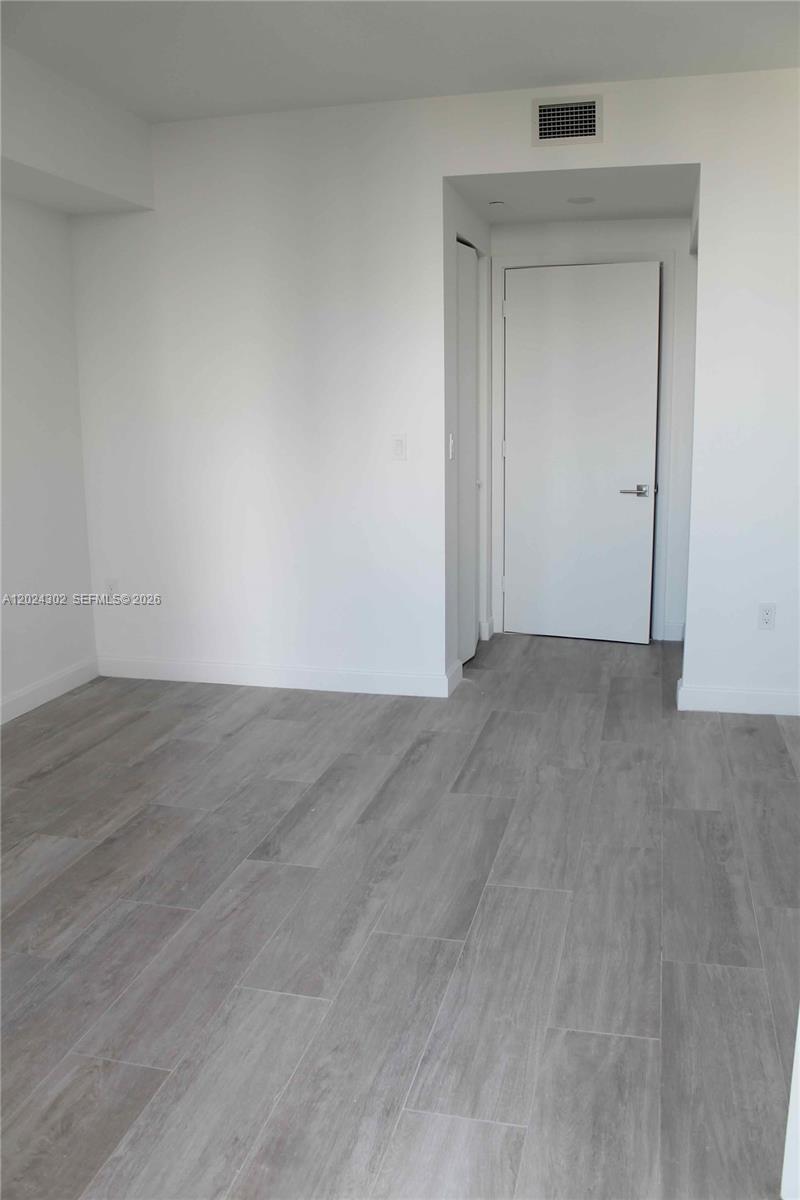 45 Southwest 9th Street, Unit 2109 Miami, FL 33130 - Photo 17 of 40 an empty room with wooden floor & closet