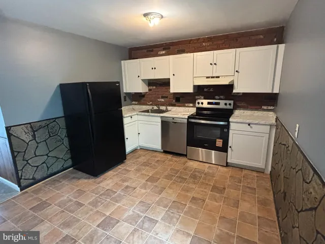 a kitchen with stainless steel appliances granite countertop a stove a refrigerator and a cabinets