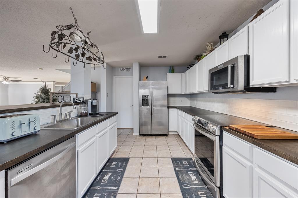 1609 Jester Court Little Elm, TX 75036 - Photo 15 of 34 a kitchen with a sink stainless steel appliances and cabinets