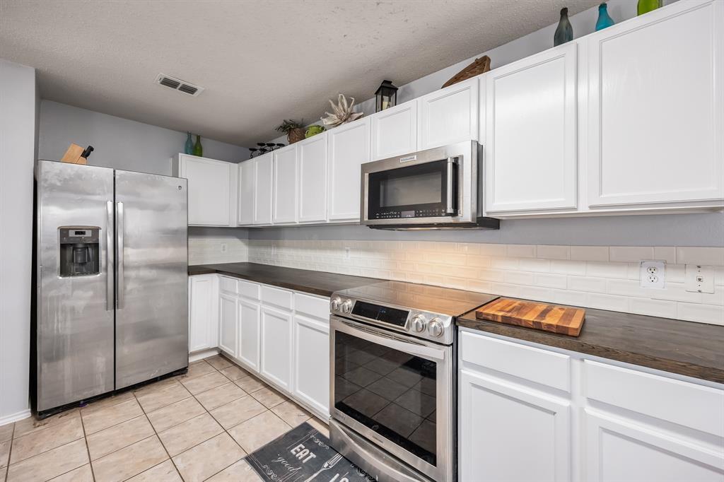 1609 Jester Court Little Elm, TX 75036 - Photo 17 of 34 a kitchen with granite countertop a sink stove and refrigerator
