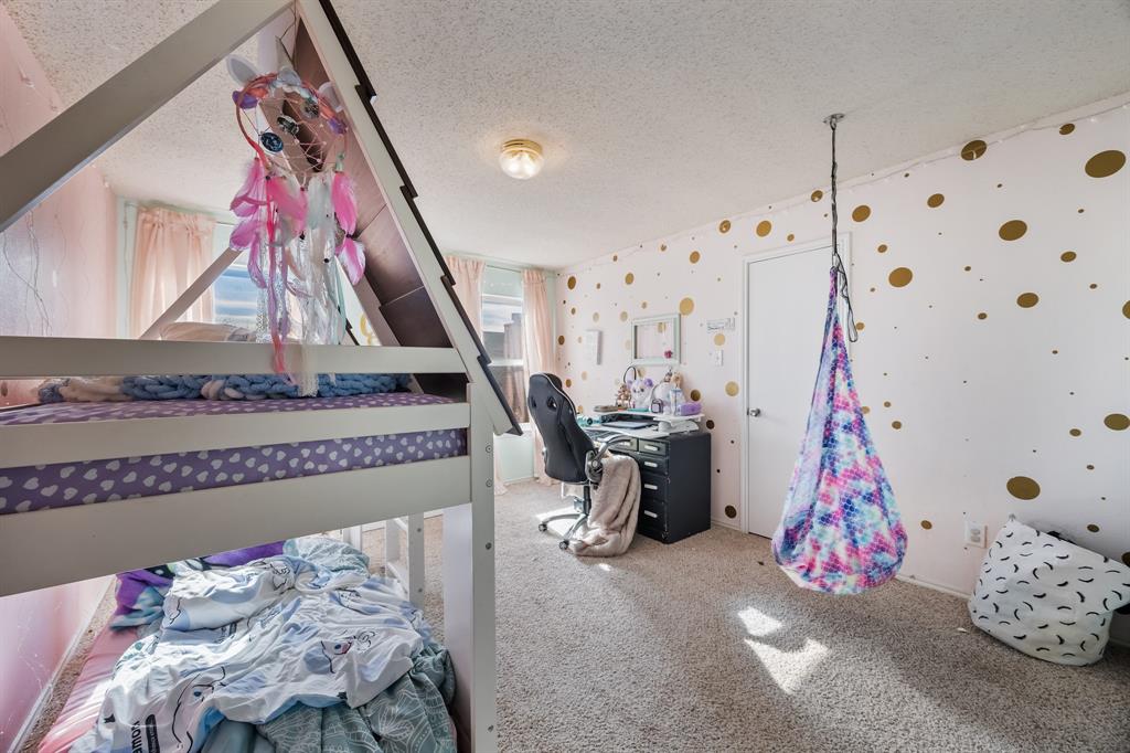 1609 Jester Court Little Elm, TX 75036 - Photo 23 of 34 a bedroom with bed and a chandelier