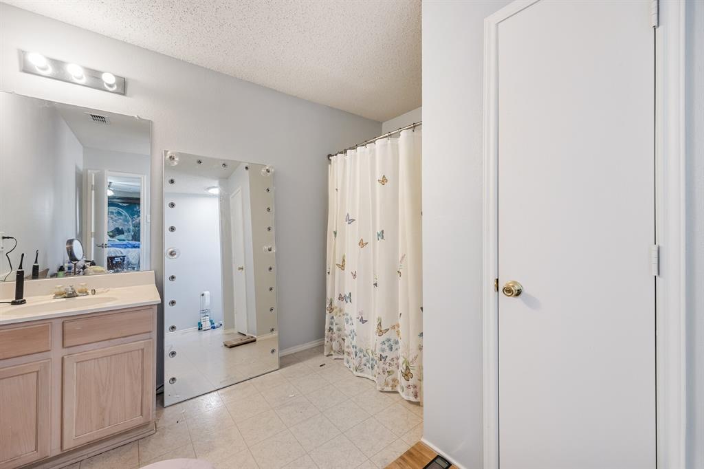 1609 Jester Court Little Elm, TX 75036 - Photo 28 of 34 a bathroom with a sink a mirror a shower and a double vanity