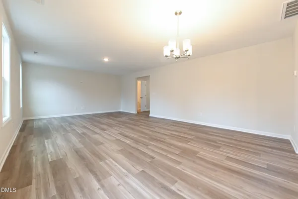 an empty room with wooden floor and ceiling fan