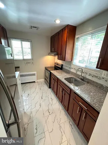 a kitchen with stainless steel appliances granite countertop a sink stove and cabinets