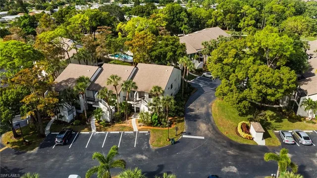 an aerial view of a house with a yard and large trees