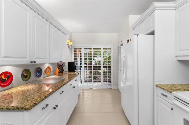 a kitchen with granite countertop a refrigerator and a sink