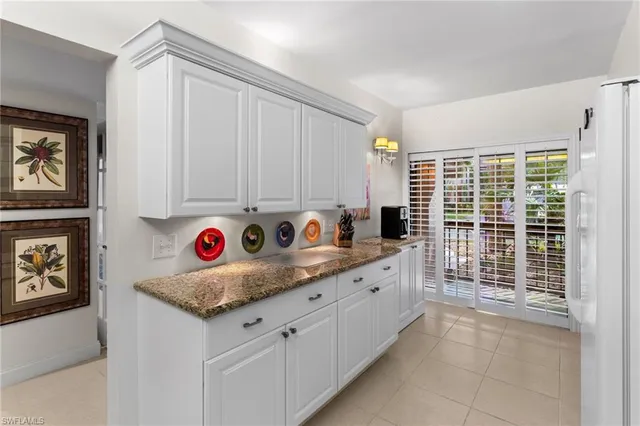 a kitchen with granite countertop a sink and a refrigerator
