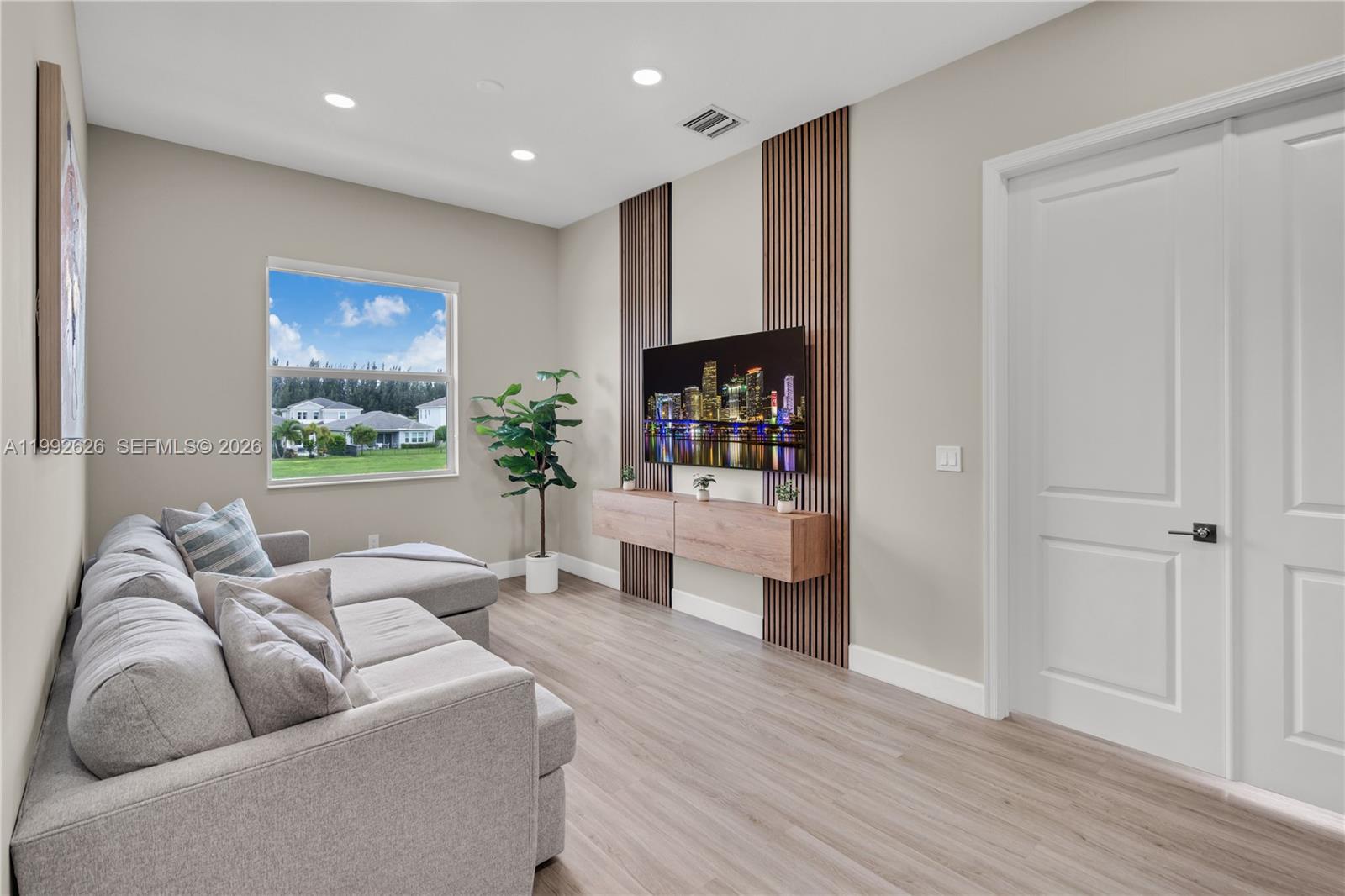15769 Hummingbird Lane Loxahatchee, FL 33470 - Photo 20 of 54 a living room with furniture and a book shelf