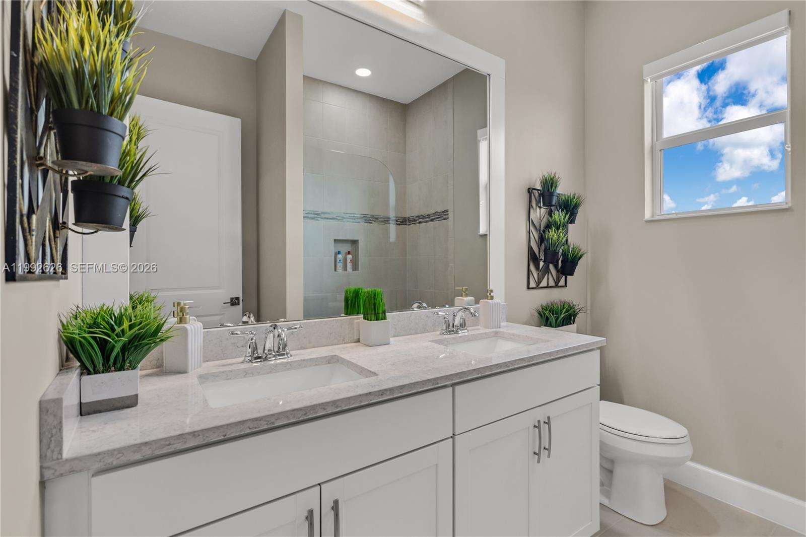 15769 Hummingbird Lane Loxahatchee, FL 33470 - Photo 25 of 54 a bathroom with a granite countertop sink a toilet and a mirror