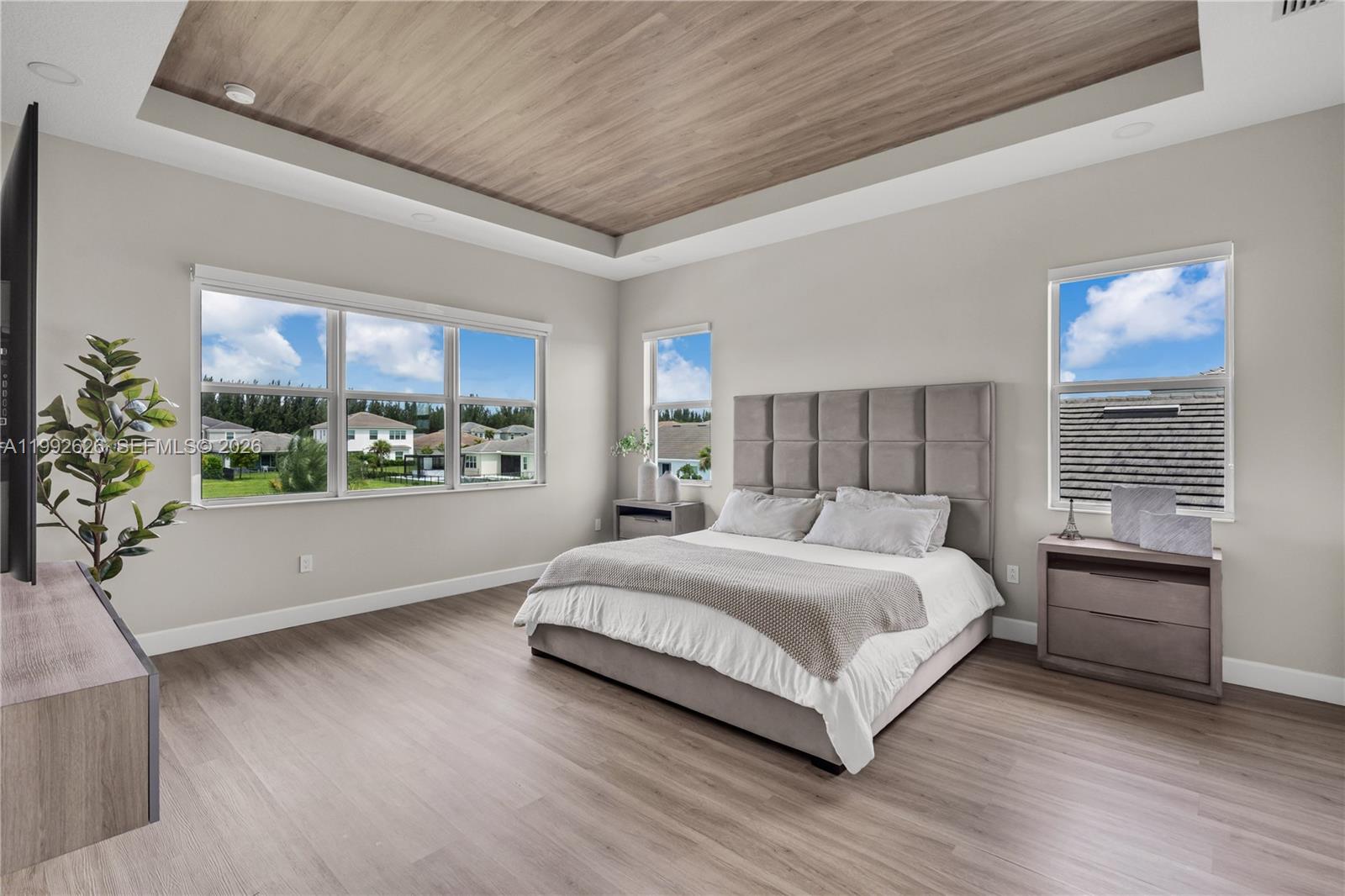 15769 Hummingbird Lane Loxahatchee, FL 33470 - Photo 31 of 54 a bedroom with a large bed and a large window