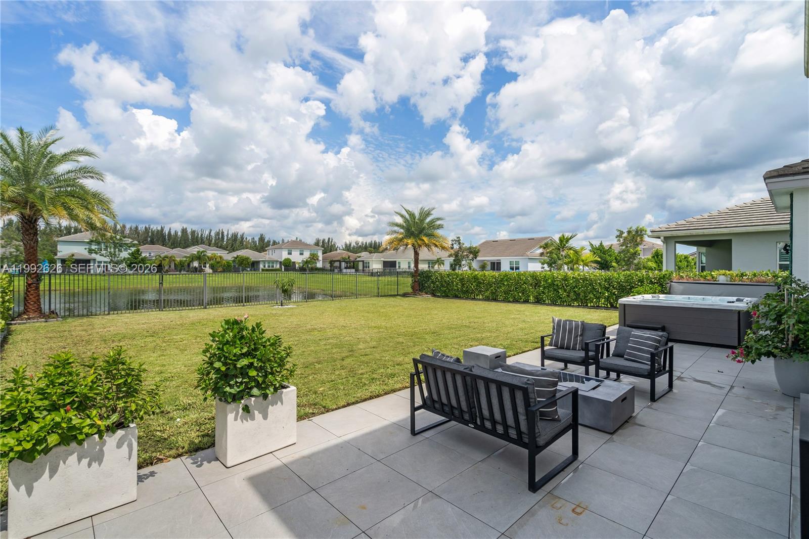 15769 Hummingbird Lane Loxahatchee, FL 33470 - Photo 39 of 54 a view of a patio with a table chairs and a lake view