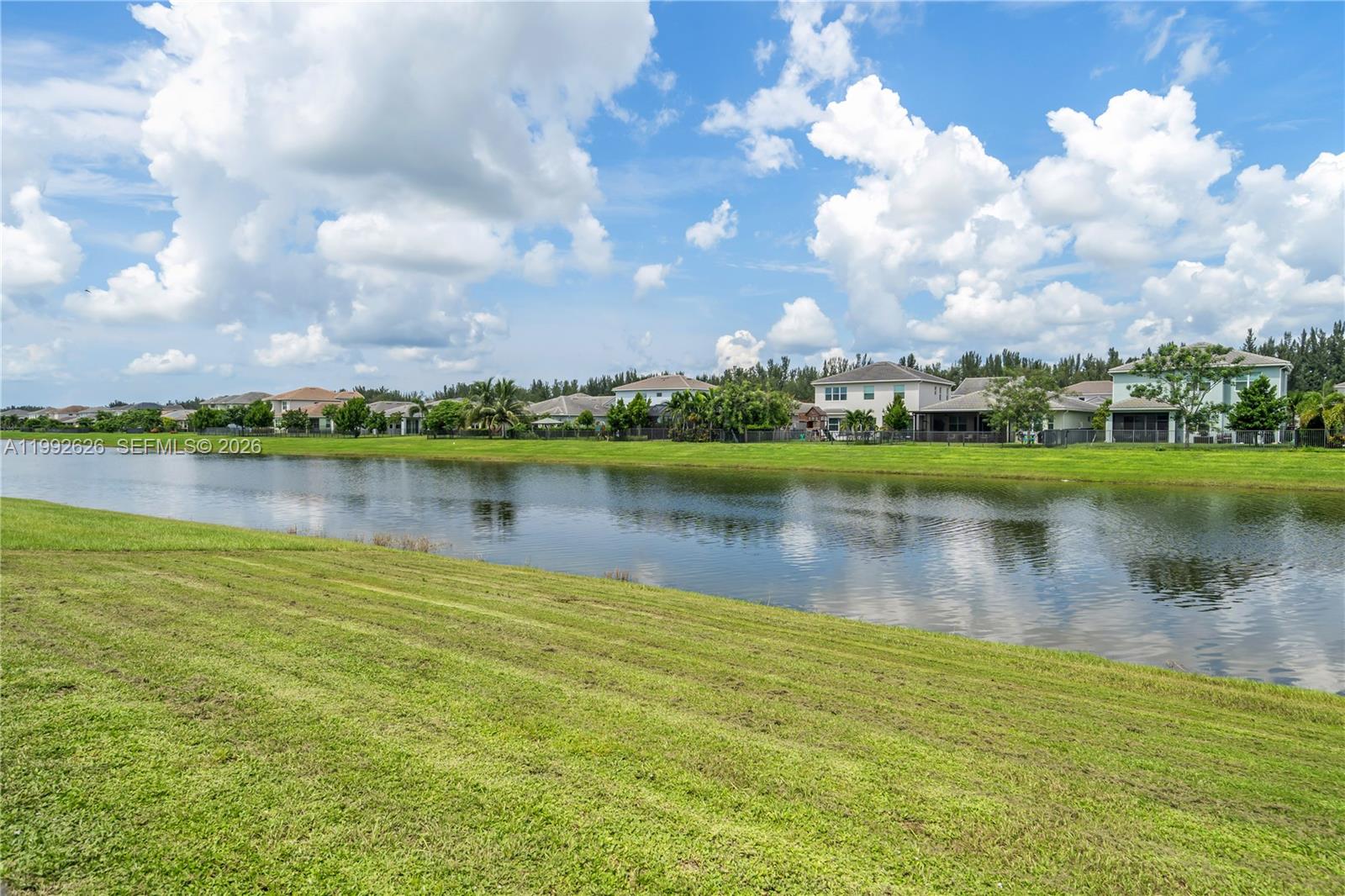 15769 Hummingbird Lane Loxahatchee, FL 33470 - Photo 42 of 54 a view of a lake with houses in the background