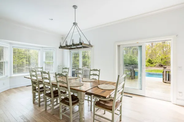 a dining room with furniture a chandelier and wooden floor