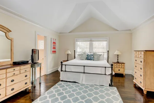 a bedroom with a bed and dresser with mirror