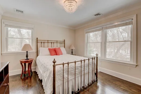 a bedroom with a bed a chandelier and a window