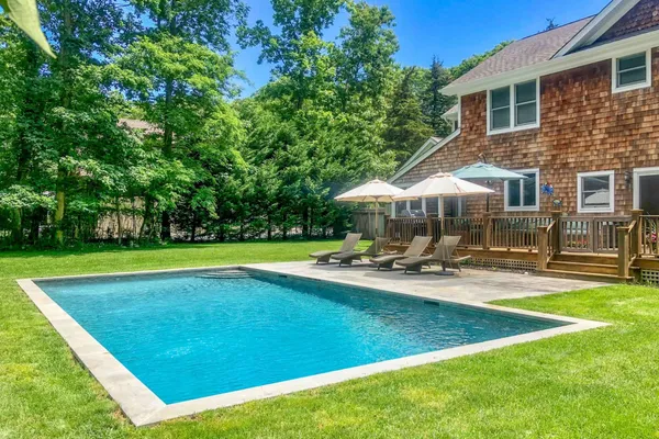 a view of a house with swimming pool and sitting area