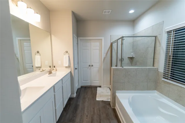 a bathroom with a bathtub sink and mirror