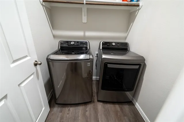 a utility room with wooden floor washer and dryer