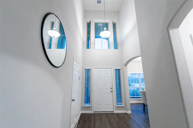 an empty room with wooden floor and mirror