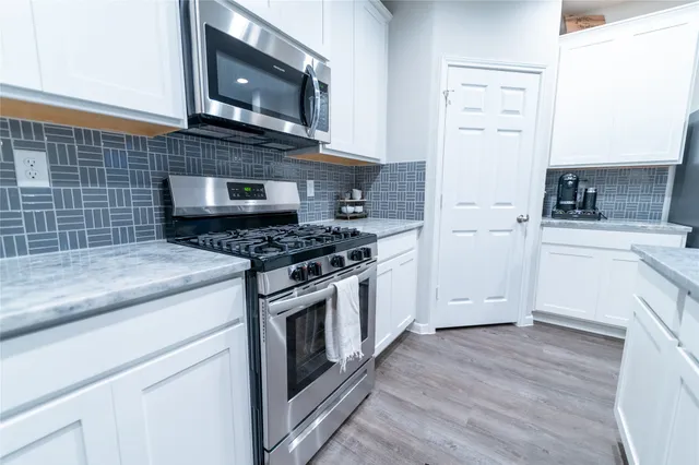 a kitchen with granite countertop a stove and a microwave