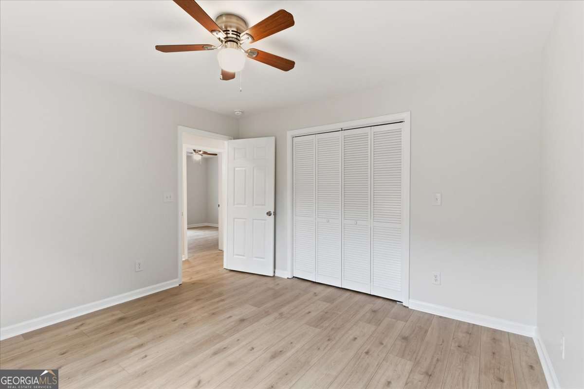 119 Jackson Street Northeast Rome, GA 30161 - Photo 28 of 57 an empty room with wooden floor ceiling fan and windows