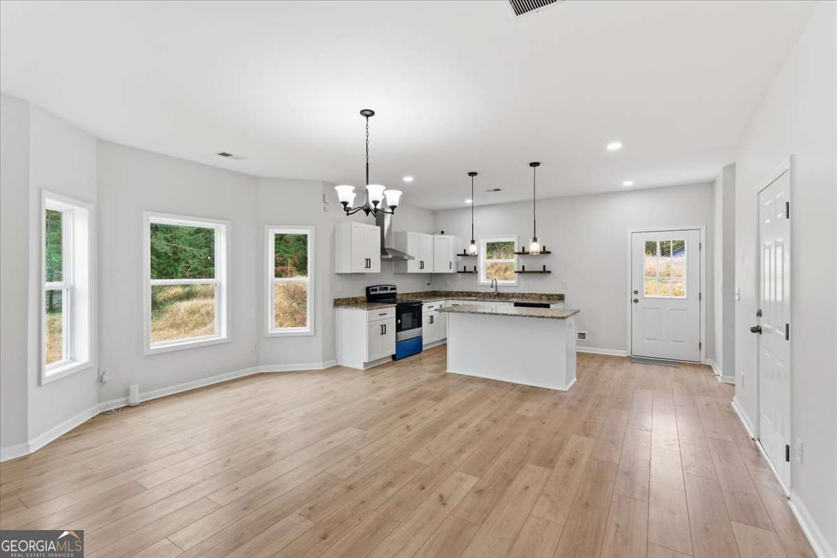 119 Jackson Street Northeast Rome, GA 30161 - Photo 7 of 57 a kitchen with stainless steel appliances kitchen island wooden floors cabinets and a chandelier