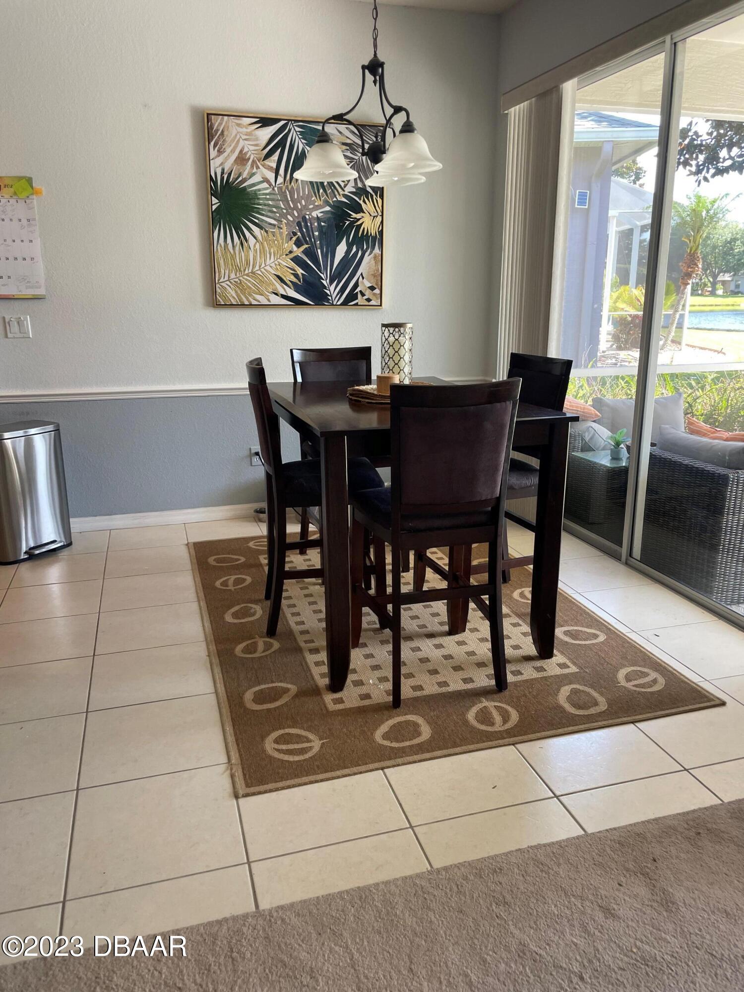 6129 Pheasant Ridge Drive Port Orange, FL 32128 - Photo 15 of 25 a dining room with a glass table and chairs