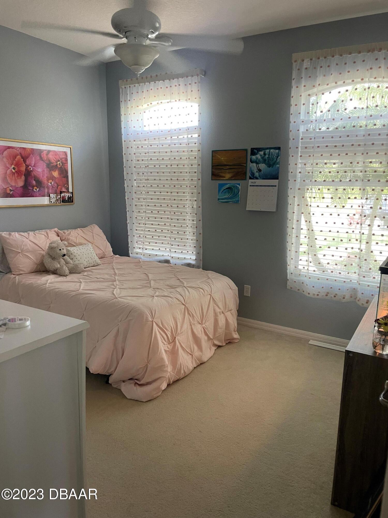 6129 Pheasant Ridge Drive Port Orange, FL 32128 - Photo 16 of 25 a bedroom with a bed and a flat tv screen on dresser