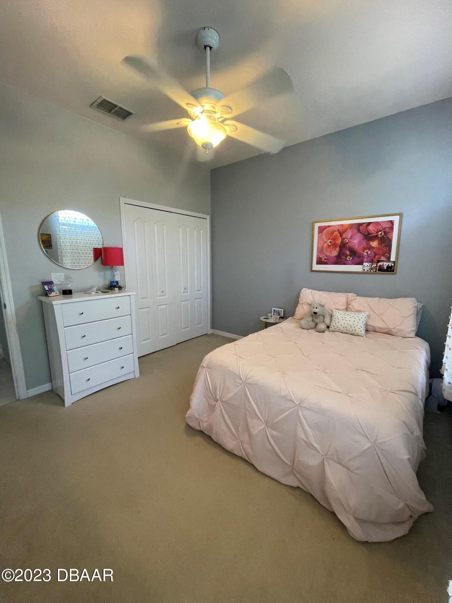 6129 Pheasant Ridge Drive Port Orange, FL 32128 - Photo 17 of 25 a bedroom with a bed and a chandelier